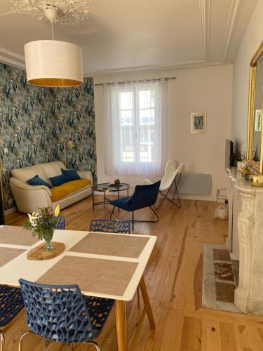 un salon avec une table et des chaises dans l'établissement La Léonardine à deux pas du château royal, à Amboise