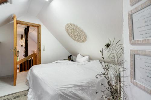 a bedroom with a white bed and a staircase at Quartier Sängerstadt in Finsterwalde