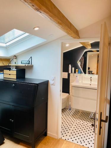 La salle de bains est pourvue d'une coiffeuse noire et d'un lavabo. dans l'établissement Douillet et coquet appartement climatisé - Parking privé sur réservation - Centre Montpellier, à Montpellier