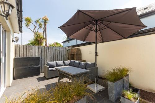 a patio with a table and an umbrella at Greystones Harbour Studio in Greystones