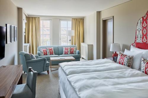 a hotel room with a bed and a couch at Strandhotel Zingst in Zingst