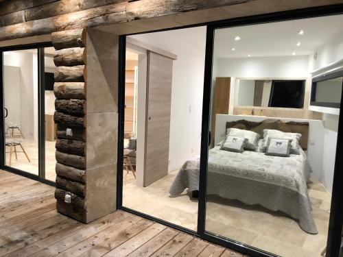 ein Schlafzimmer mit einem Bett und einem großen Spiegel in der Unterkunft Lodge entre ciel et mer in Saint-Cyr-sur-Mer