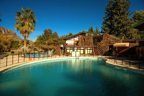 una gran piscina de agua frente a una casa en Hotel Valle Grande en San Rafael