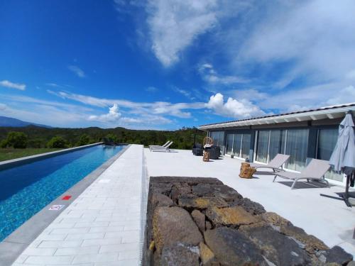 a patio with a swimming pool next to a house at PicoTerrace in Madalena