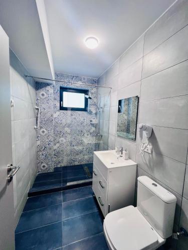 a bathroom with a toilet and a sink at Sea Panorama Apartments & Free Parking in Năvodari