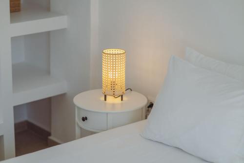 a lamp sitting on a table next to a bed at Rose House and Apartments in Andiparos