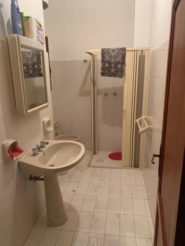 un bagno bianco con lavandino e doccia di Casa vacanza Lipari a Città di Lipari