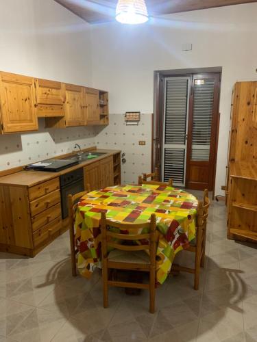 una cucina con tavolo, sedie e lavandino di Casa vacanza Lipari a Città di Lipari