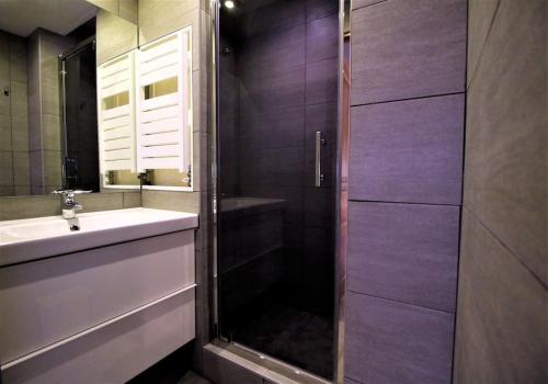 a bathroom with a shower and a sink and a mirror at Gites La Palombière La Muzardie in Bézenac