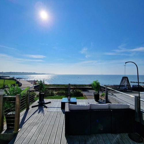 a wooden deck with a view of the ocean at Stunning Beachfront House, Herne Bay, Kent in Kent