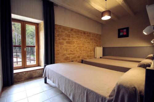 a bedroom with two beds and a window at Gites La Palombière La Muzardie in Bézenac