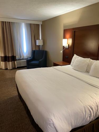 a hotel room with a large bed and a blue chair at Comfort Inn Indianapolis South I-65 in Indianapolis