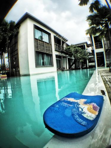 a blue surfboard in the water in a swimming pool at Paragon Inn in Lat Krabang