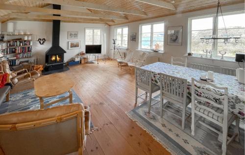 a living room with a table and chairs and a fireplace at 4 Bedroom Lovely Home In Fagerfjäll in Gåseknöde