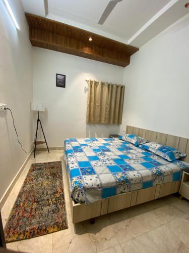een slaapkamer met een bed en een tapijt bij The Samaa Homes -By SAS Group in Dehradun