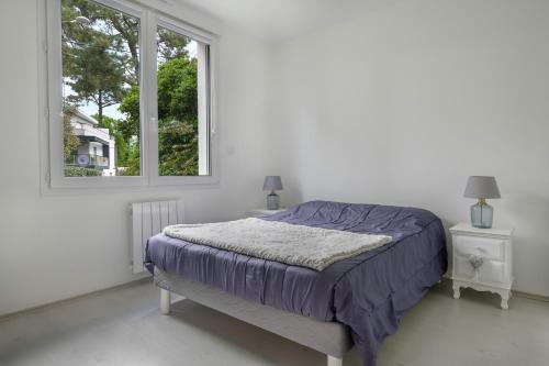 a bed in a white room with a window at Maison pour 4 avec jardin à 1km de la plage in La Baule