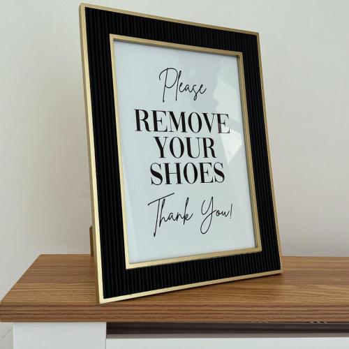 a framed picture of pray remove your shoes thank you at Deluxe Inn Gateshead in Gateshead