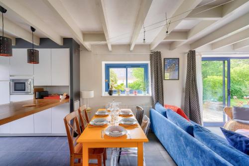 une salle à manger avec une table et un canapé bleu dans l'établissement Maison coup de coeur pour 6, pays Bigouden, à Combrit