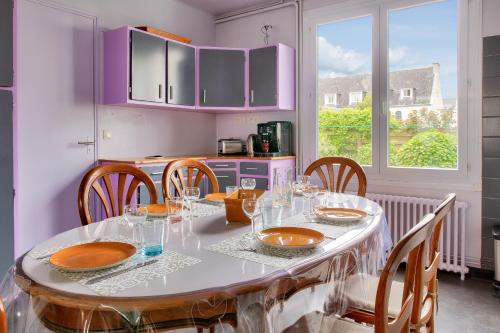 une salle à manger avec une table et des chaises ainsi qu'une cuisine dans l'établissement Concarneau - 300m des plages, à Concarneau