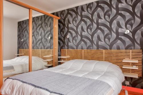 a bedroom with two beds and a black and white patterned wall at Concarneau - 300m des plages in Concarneau