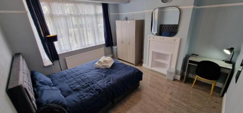 a bedroom with a bed with a cat laying on it at Rowan Crescent's Luxury Stay-In4 in Streatham Vale