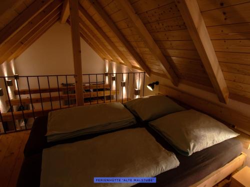 a large bed in a room with a wooden ceiling at Ferienhäuser Seiffen in Seiffen