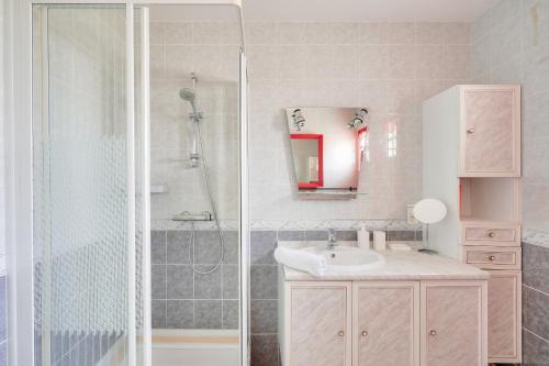 une salle de bain avec un lavabo et une douche dans l'établissement Jolie maison familiale et colorée pour 6, au Guilvinec