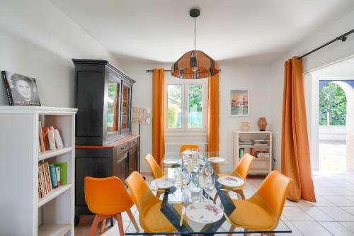 - une salle à manger avec une table et des chaises orange dans l'établissement Jolie maison familiale et colorée pour 6, au Guilvinec