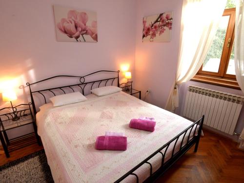 a bedroom with a bed with two pink pillows on it at Apartments Antonella in Zagreb
