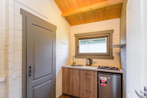 a small kitchen with a sink and a door at Nameliai Penkios gulbės in Šventoji