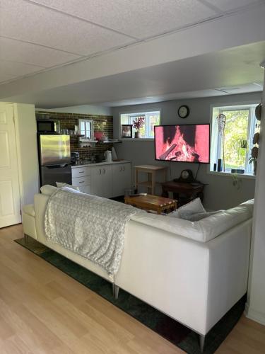 - un salon avec un canapé blanc et une télévision dans l'établissement Nature Retreat in the city, à Ottawa