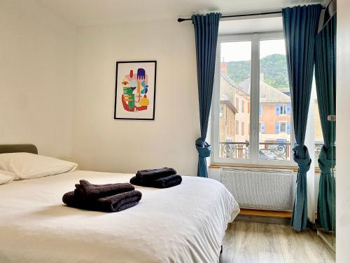 une chambre avec un lit avec deux serviettes dessus dans l'établissement Appartement cosy, à La Mure