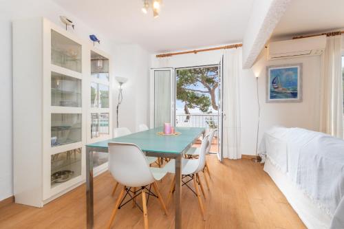 ein Esszimmer mit einem blauen Tisch und weißen Stühlen in der Unterkunft I Apartamento frente al mar en playa Tamariu in Tamariu