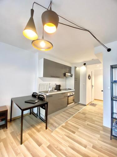 un salon avec une table et une cuisine dans l'établissement Appartement cosy, à La Mure