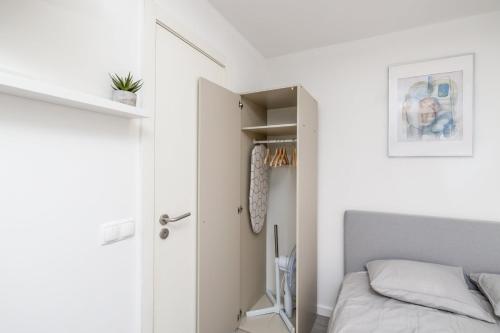 um pequeno quarto com uma cama e um closet em GuestReady - Minimalist Studio In Downtown Lisbon em Lisboa