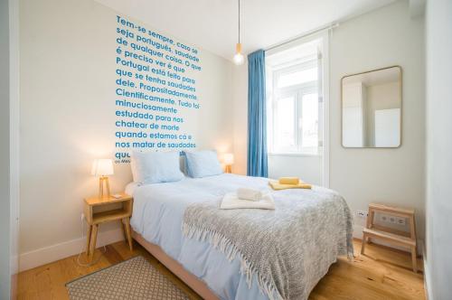 sypialnia z dużym łóżkiem i dużym oknem w obiekcie GuestReady - Chic and vibrant stay near Anjos w Lizbonie