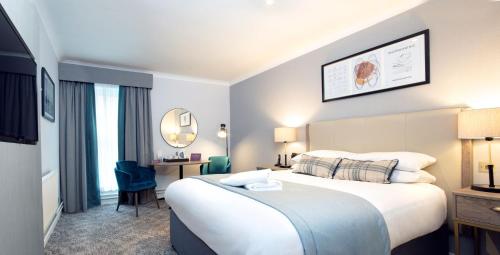 a hotel room with a large bed and a desk at Eastwood Hall in Eastwood