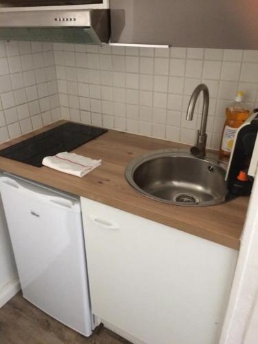 une cuisine avec un évier et un plan de travail dans l'établissement Studios dans l'hyper centre Bordeaux, à Bordeaux