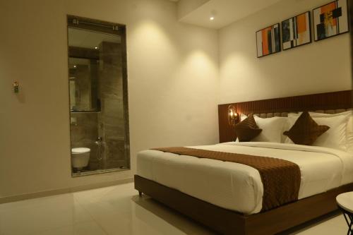 a bedroom with a large bed and a window at Kings Kraft Tremezzo Inn, Somnath in Somnath