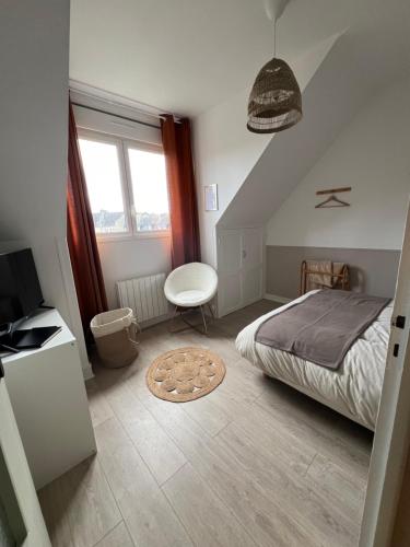 a bedroom with a bed and a desk and a television at Appartement charmant et confortable en centre-ville in Condé-sur-Noireau
