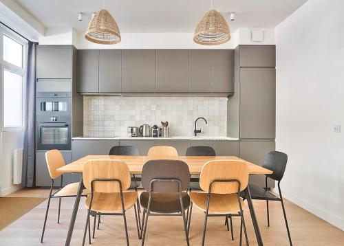 une cuisine avec une table et des chaises en bois dans l'établissement GuestReady - Modern flat near Latin Quarter!, à Paris