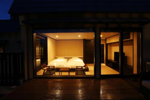 a bedroom with a bed and a window at night at Taikyourou in Miyazu