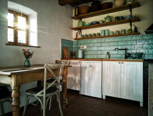 a kitchen with a wooden table and a sink at Templomdomb Vendégház Dunakanyar in Pilismarót