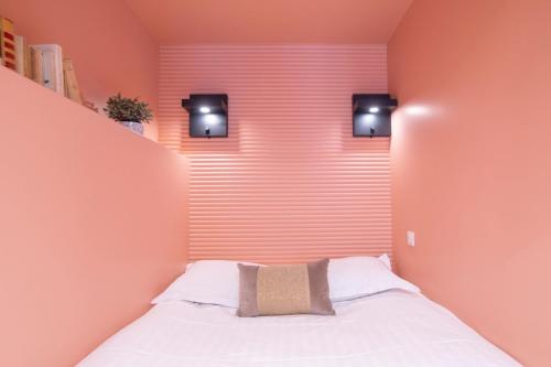 - une chambre avec un lit et deux lumières sur le mur dans l'établissement GuestReady - Apt near Parc de la Villette, à Paris