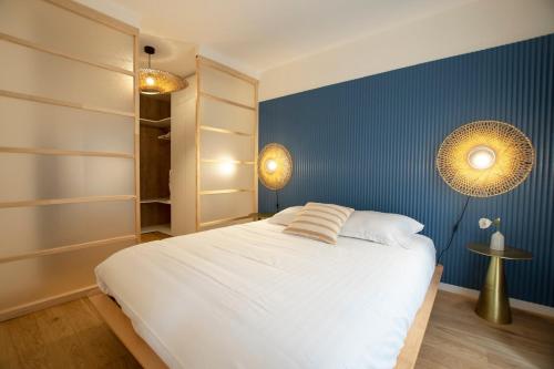 - une chambre avec un lit blanc et un mur bleu dans l'établissement GuestReady - Apt near Parc de la Villette, à Paris