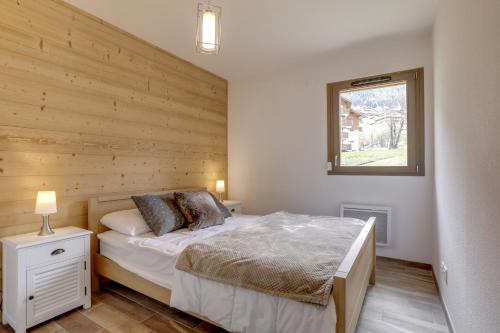 - une chambre avec un lit et un mur en bois dans l'établissement 4 Eléments 4ED301 MODERN & CHARMING 6 Pers, à Châtel