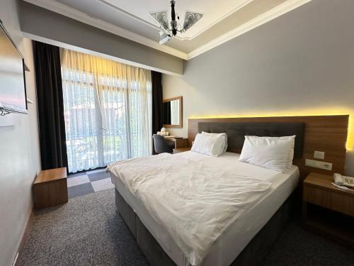 a bedroom with a large bed and a large window at Inceli Hotel in Uzungöl