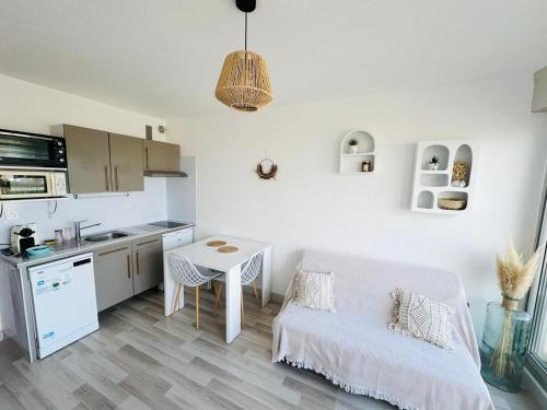 un salon avec une table et une cuisine dans l'établissement Studio vue mer avec WIFI, à Mauguio