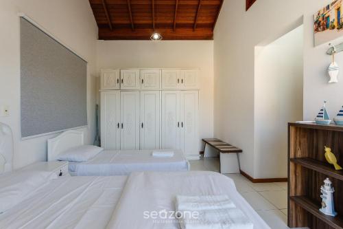 a bedroom with two beds and a cabinet at Casa em condo com piscina, a 300m da praia ALI024 in Florianópolis