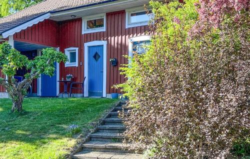 ein rotes Haus mit einer blauen Tür und einer Treppe davor in der Unterkunft Nice Apartment In Markaryd in Markaryd